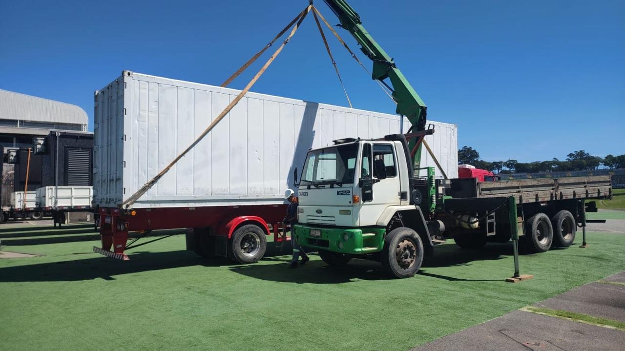 Caminhão Munck da SOS Transem içando container em operação industrial